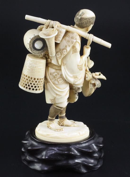 A Japanese ivory okimono of a basket seller, early 20th century, 14.5cm, wood stand